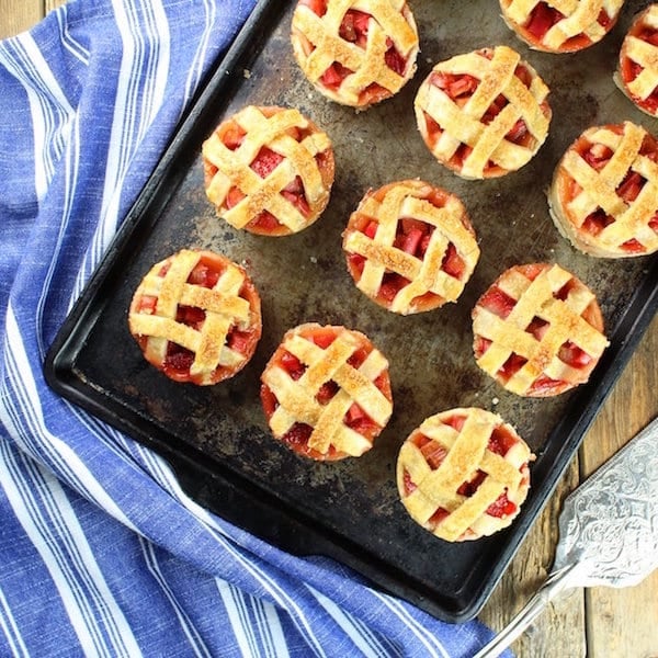 Mini strawberry rhubarb pies on a baking sheet