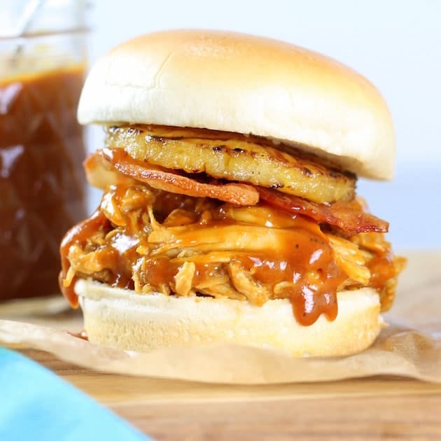 Close up eye level Hawaiian chicken bacon slider on cutting board