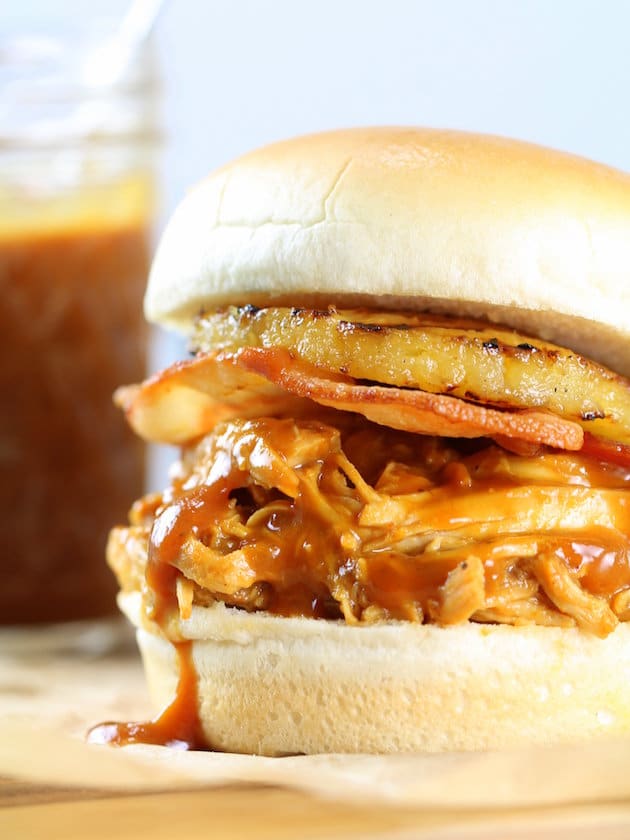 Very close up pulled chicken slider with grilled pineapple ring and bacon 