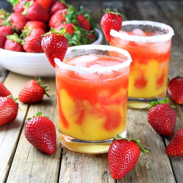 Two Honey Mango Strawberry Margaritas with salted rims