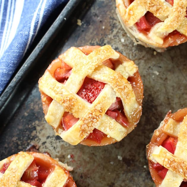 Close up of Mini Strawberry Rhubarb Pies on baking sheet 