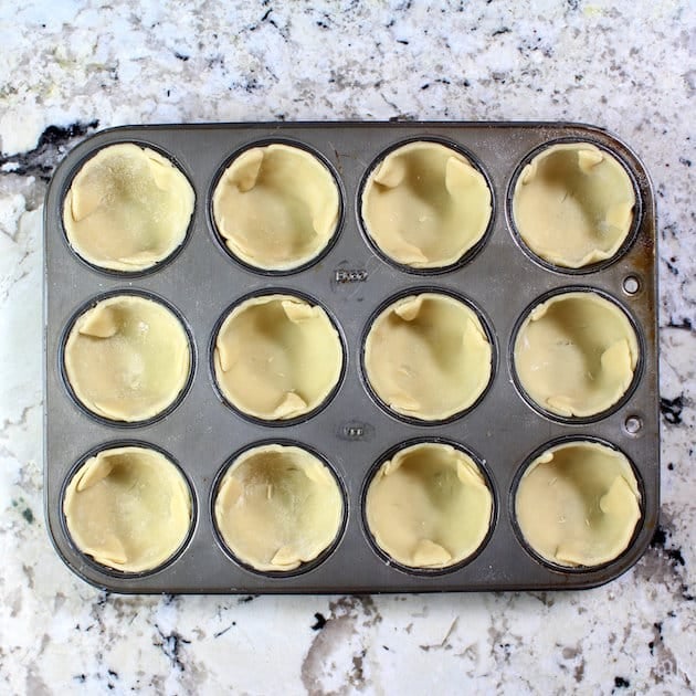 Stuffing pastry dough into muffin tin