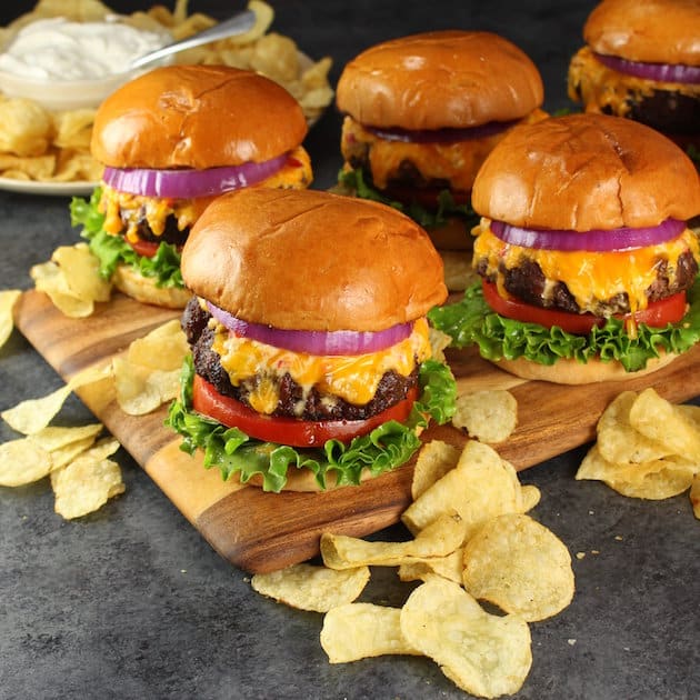 Five Cheese and Bacon Burgers on a cutting board 