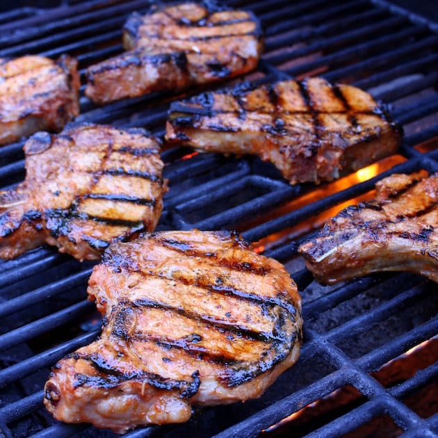 Six Pork chops grilling on grill