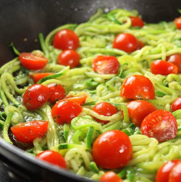 Zucchini noodles and tomatoes in a skillet