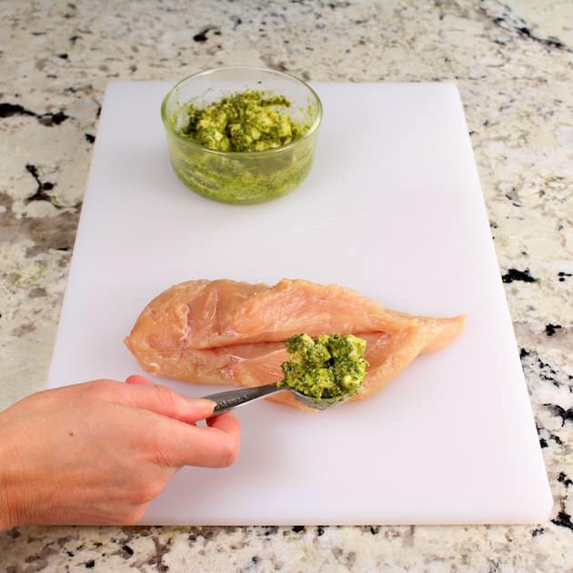 Stuffing a sliced chicken breast with pesto