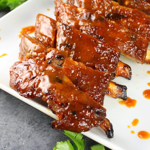 A close-up eye-level image of BBQ Baby Back Ribs on a platter.