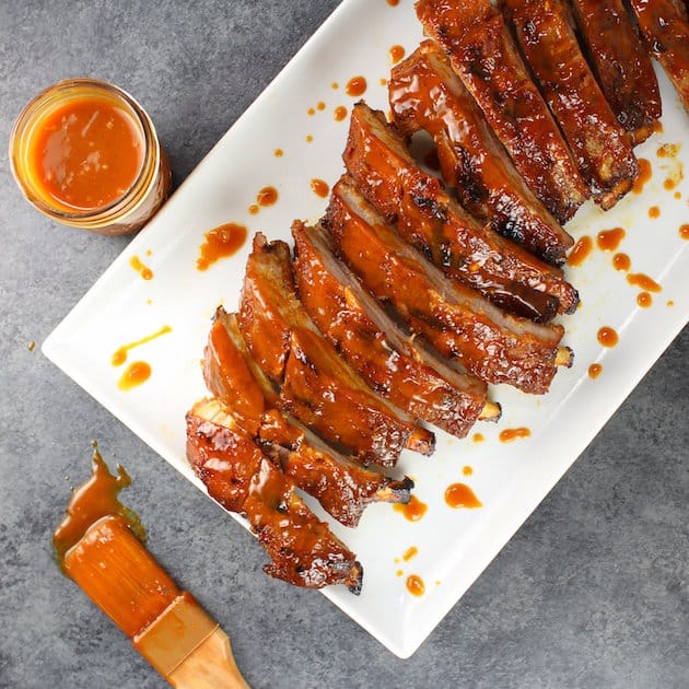 \"Secret Sauce\" BBQ Baby Back Ribs Image of ribs on platter with sauce and brush