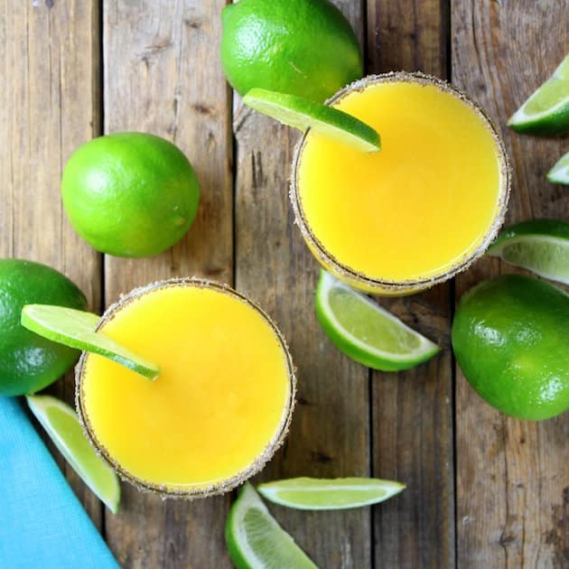 Smoky Mango Margaritas on table with fresh limes