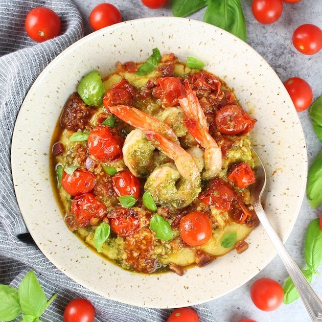 Bowl of parmesan polenta topped with pesto shrimp