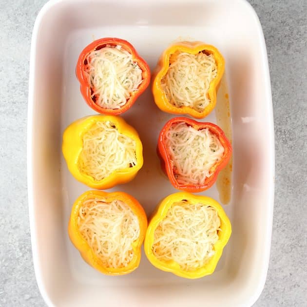 Stuffing shredded mozzarella cheese into lasagna stuffed peppers