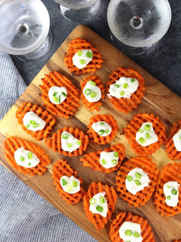 Sweet potato waffle fries on a cutting board with cheese dip