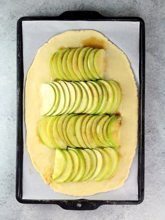Galette dought with sliced apples in rows