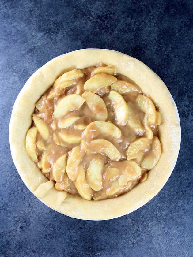 Apple pie filing in pie crust before cooking.