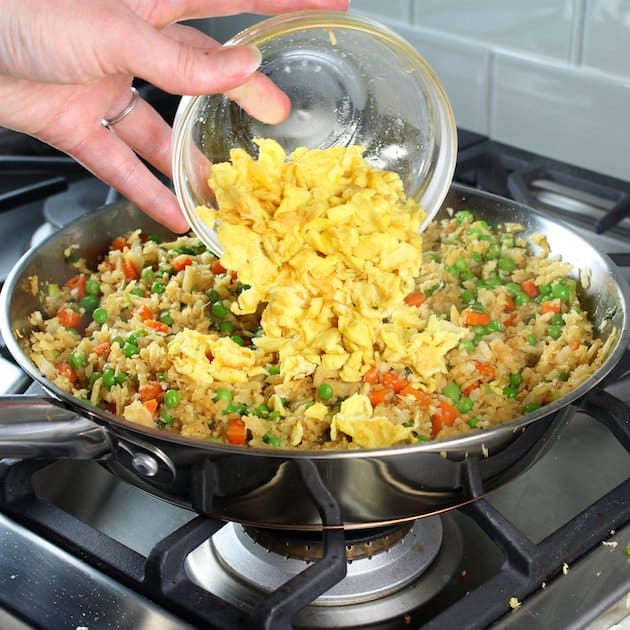  Adding egg to fried rice in saucepan