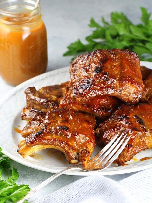 A plate of baby back ribs with a fork