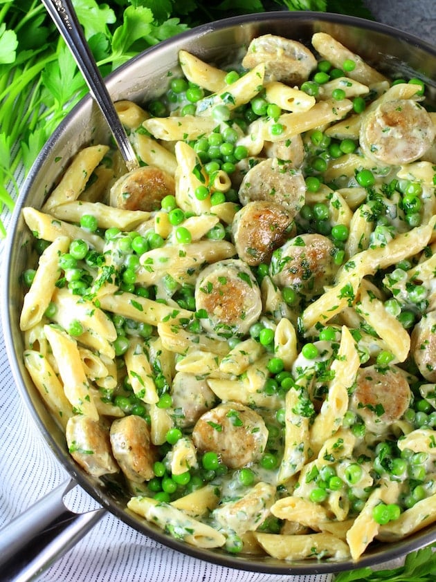 Saute pan of creamy chicken alfredo with penne and peas