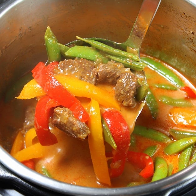 Ladle in a bowl of Instant Pot Beef Thai Red Curry 