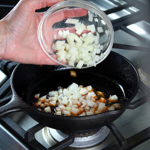 Adding onions to skillet with chorizo