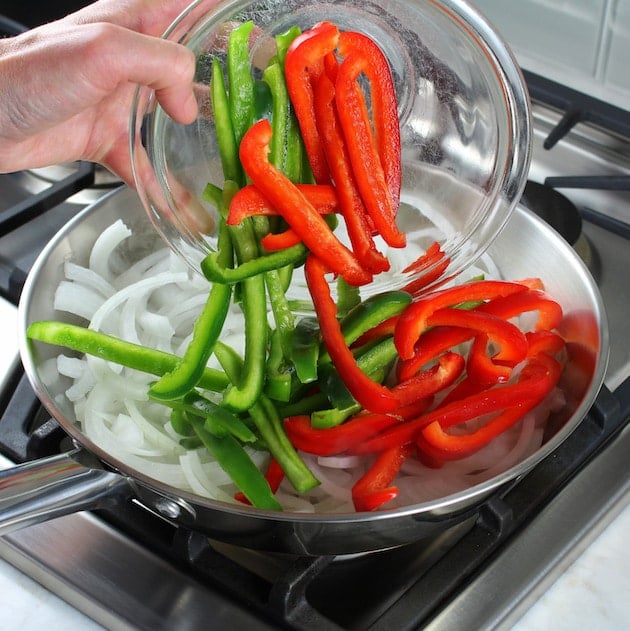 Adding onions and peppers to saute pan
