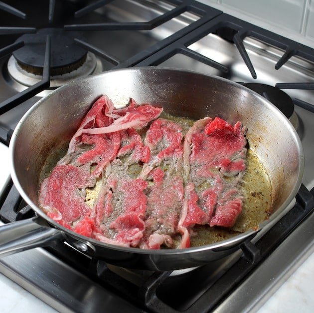 Adding steak to saute pan
