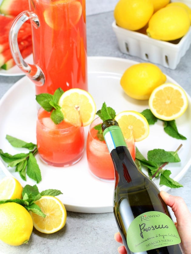 Pouring prosecco into glass of Watermelon Lemonade Prosecco Spritzer