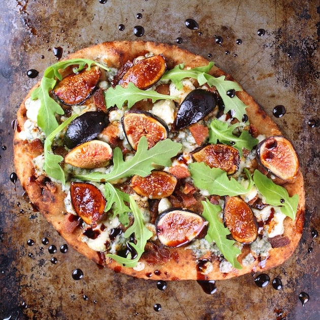 Fig pizza with balsamic on a baking sheet