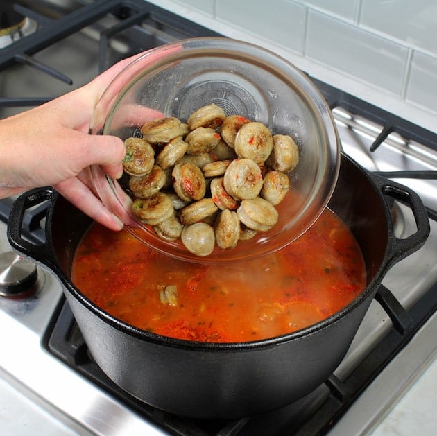 Adding chicken sausage to soup pot