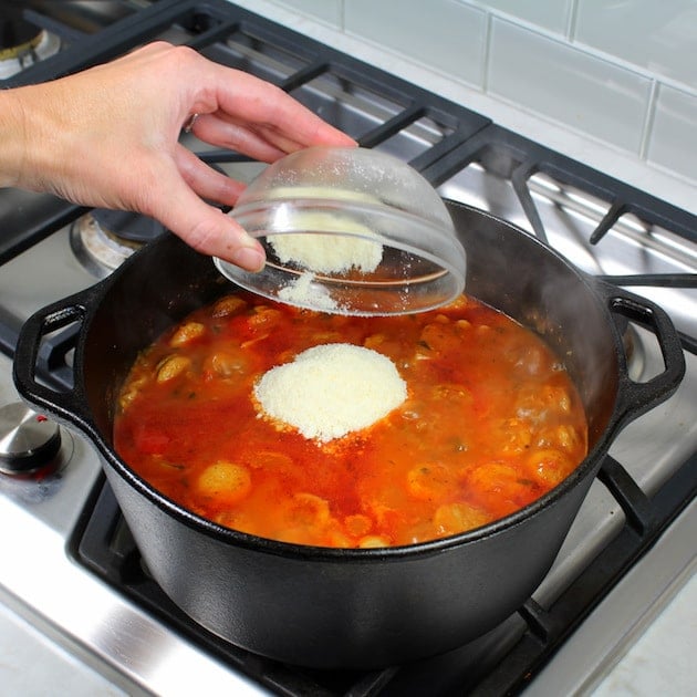 Adding parmesan cheese to soup pot