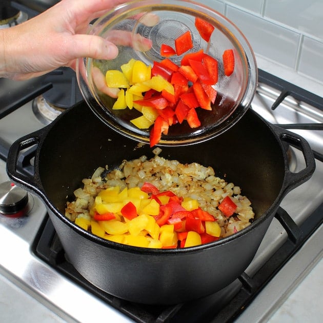 Adding bell peppers to large soup pot on stovetop