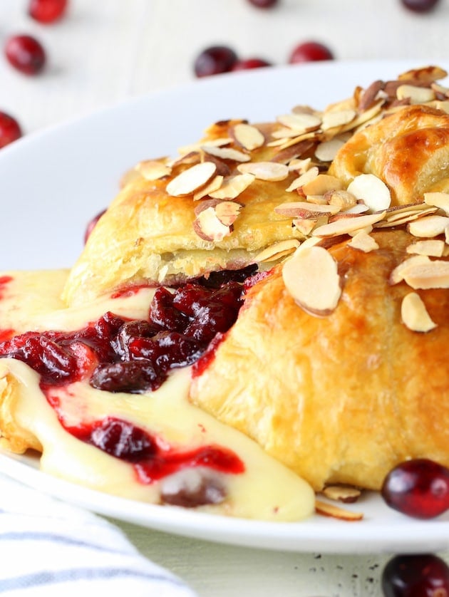 Baked puff pastry brie with cherry Cranberry sauce oozing out