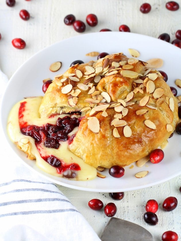 Baked brie cut open with cranberries & cheese