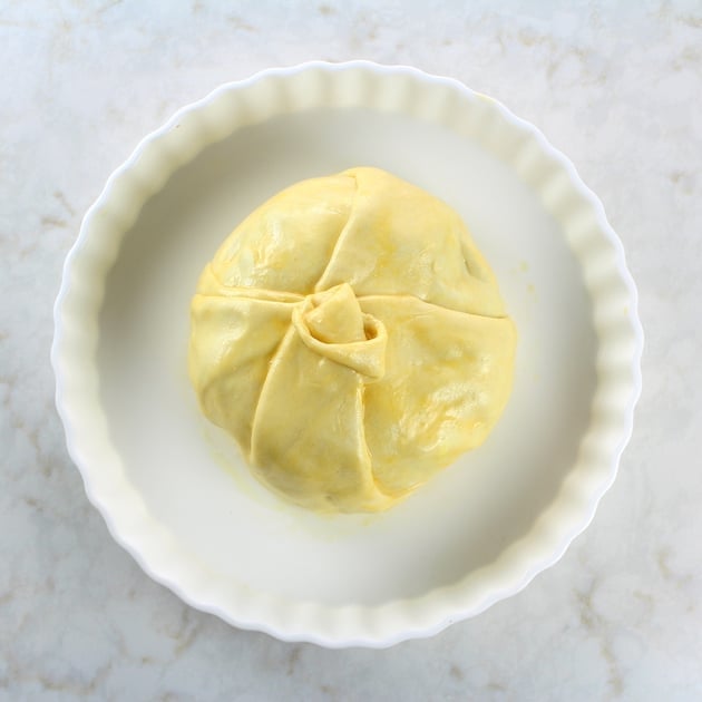 Puff pastry wrapped around brie on a baking dish