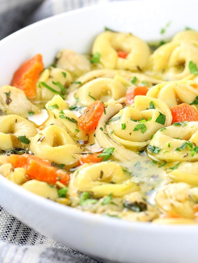 Close up eye level bowl of tortellini soup with chicken