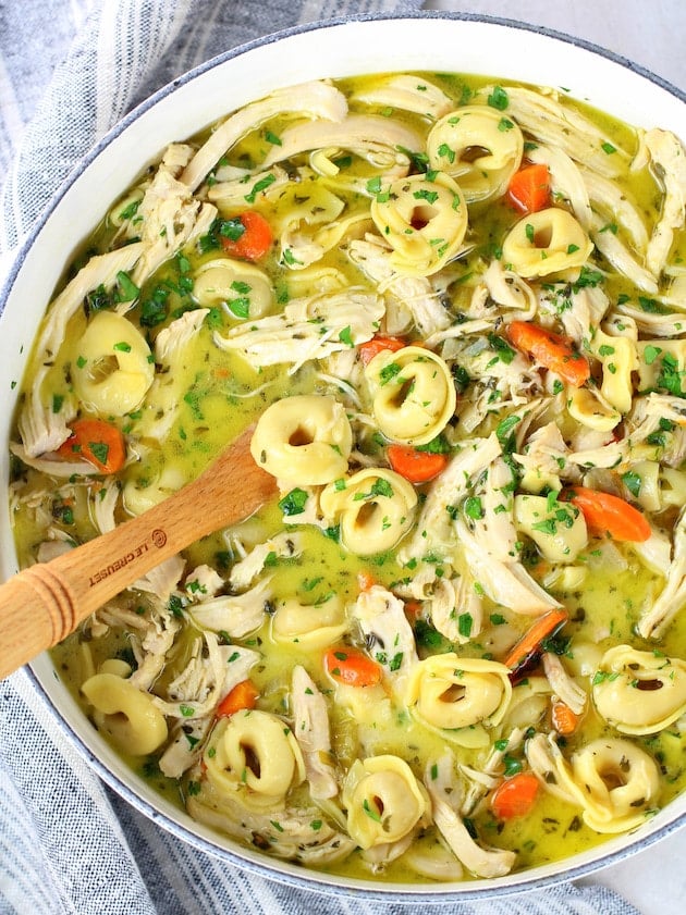 A bowl of tortellini soup with chicken