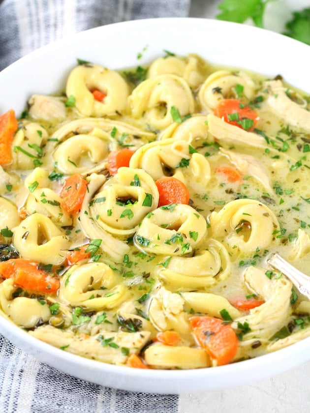 A bowl of tortellini soup with chicken