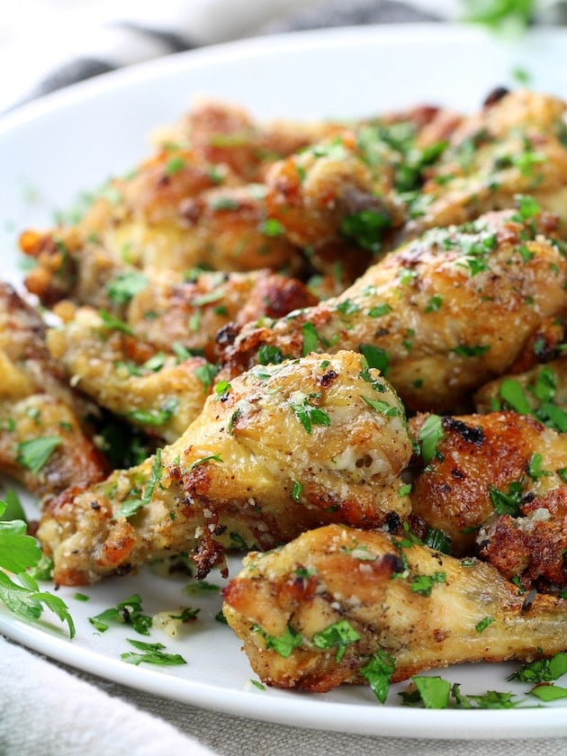 Image of Instant Pot Garlic Parmesan Chicken Wings with parsley garnish on a serving platter 