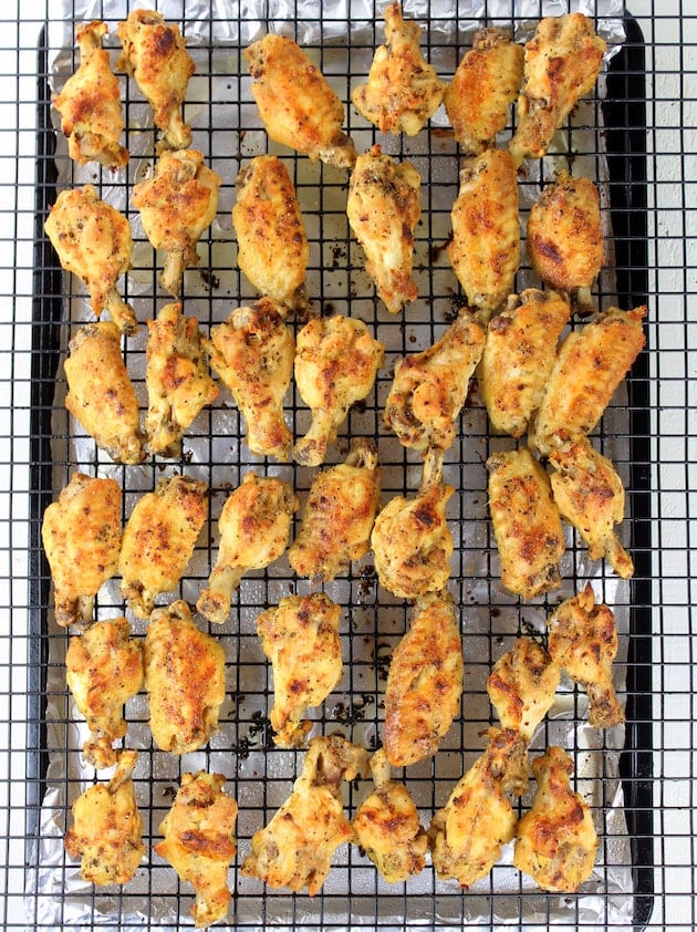 Cooked chicken wings on drying rack over baking sheet