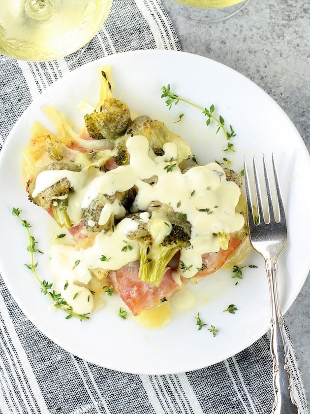 Broccoli chicken casserole on a plate topped with cheese sauce.