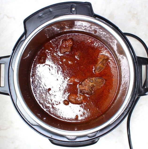 Chuck roast, cooking liquid and seasonings after it has been pressure cooked.