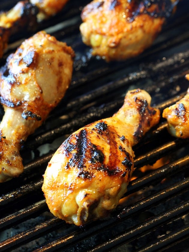 A close up of chicken drumsticks on a grill