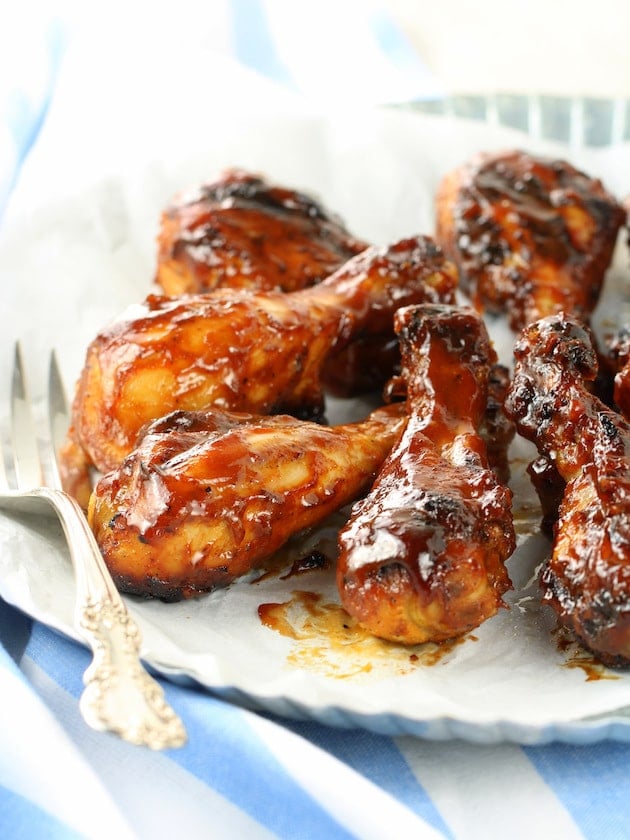 Chicken legs that have been barbecued and slathered in BBQ sauce.