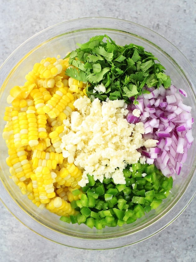 Large glass bowl with ingredients for Mexican Street Corn Salad