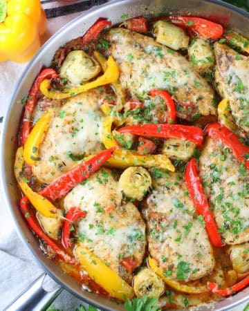 skillet of chicken breasts cooked with sliced bell peppers and menlted cheese