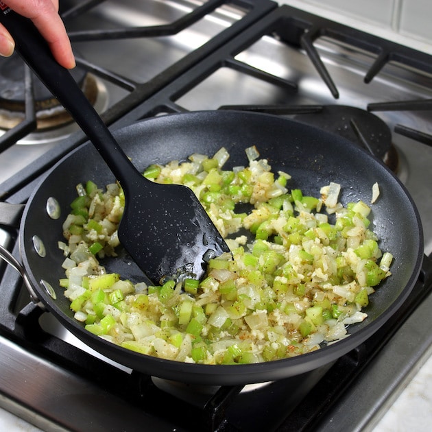 Cooking shallots and celery in saute pan on stovetop