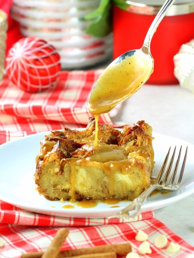 Eggnog White Chocolate Chip Bread Pudding being drizzled with whiskey sauce.