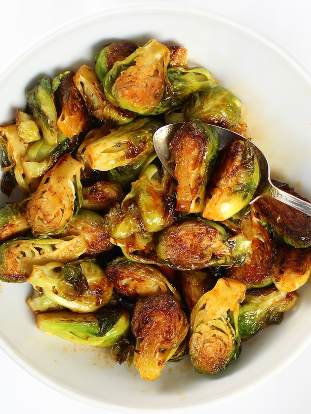 Spoon in a bowl of sauteed caramelized Brussels Sprouts