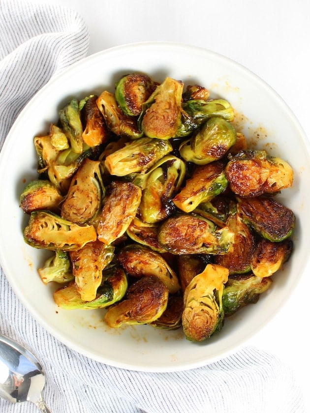 Spicy and Sweet Brussels Sprouts in a white serving dish