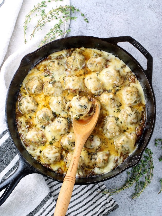 Skillet of meatballs covered in melted cheese