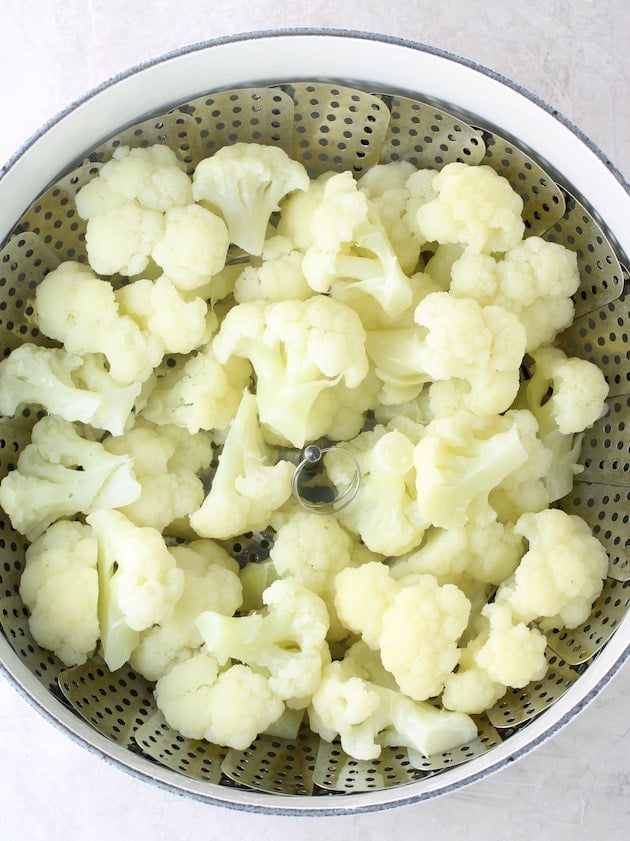 Cauliflower florets in steamer basket after cooking